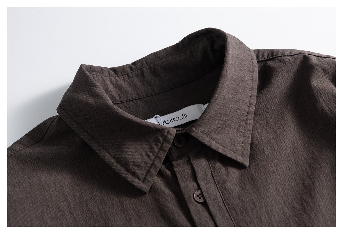 Close-up of a dark brown shirt collar, top buttons, and partially visible sewn-in brand label.