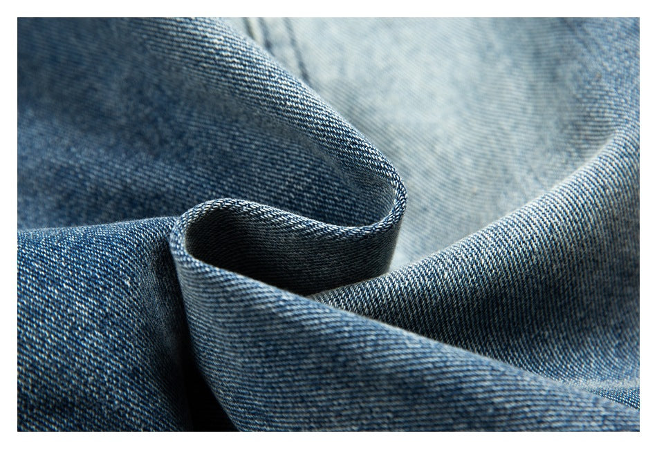 Macro view of blue denim folded to show its woven texture and contrasting fabric face.