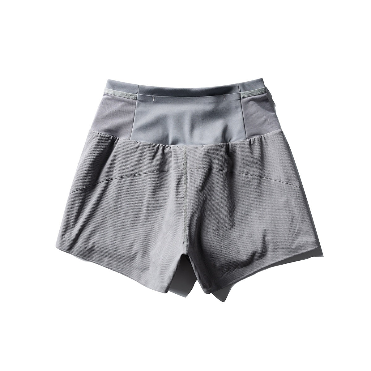Gray shorts with a wide waistband, smooth upper panels, and textured lower panels, shown from the front.