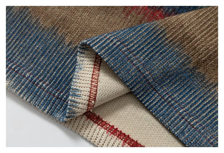 Close-up of a turned garment edge showing striped knit, cream reverse fabric, and red overlock stitching.