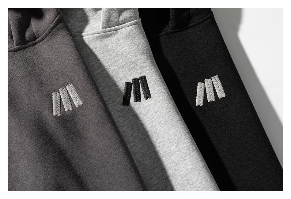 Three sweatshirt colorways—charcoal, heather gray, and black—with small embroidered chest emblems.