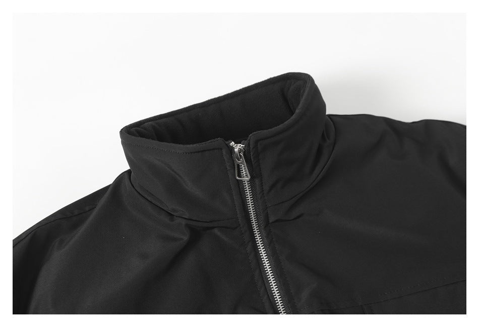 Close-up of a black jacket's raised collar and silver front zipper.