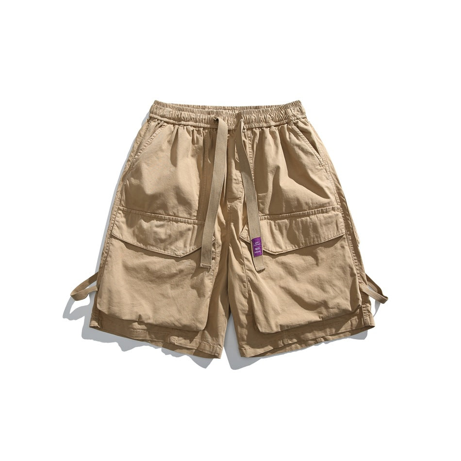 Khaki cargo shorts with large flap pockets, elastic waist and front tie strap with purple label