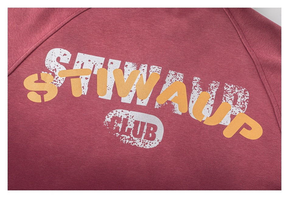 Close-up of a burgundy top with a distressed white and yellow printed graphic.
