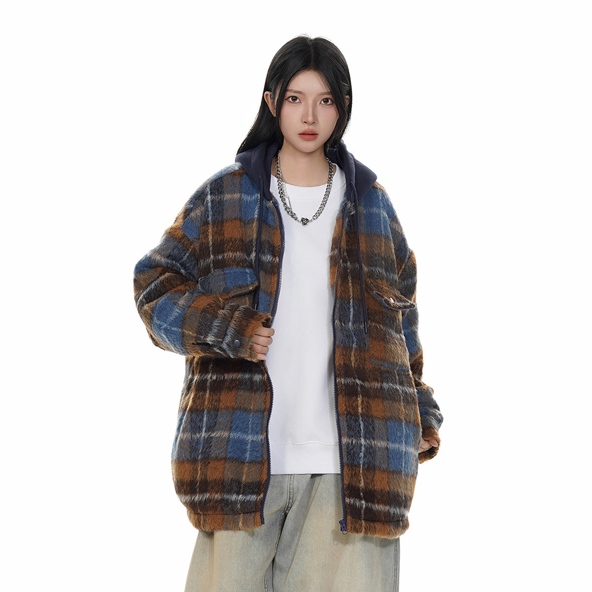 Model wearing a blue, brown, and gray plaid hooded jacket over a white top with light-wash wide-leg jeans.