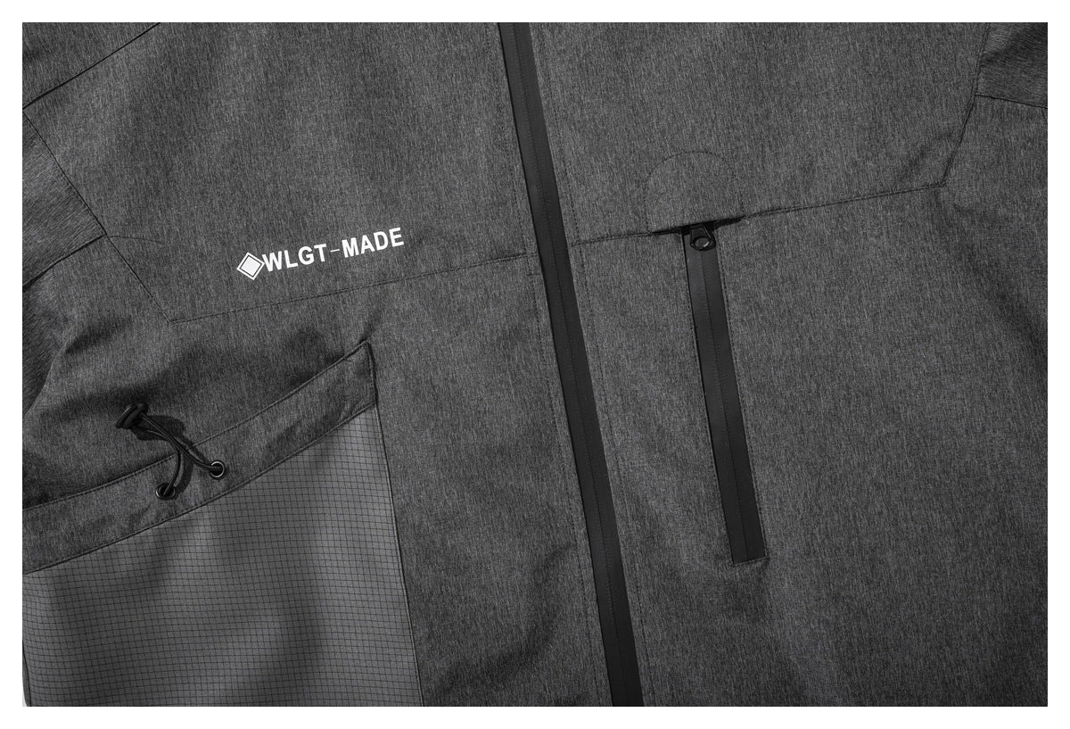 Close-up of the charcoal jacket front with zippered pockets, a grid-panel pocket and white geometric code print.