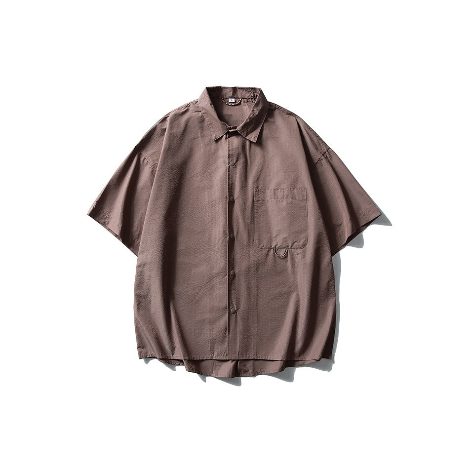 Brown mauve short-sleeve button-front shirt with collar and chest pocket, flat lay on white background