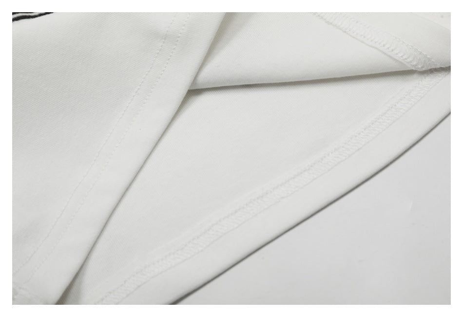 Close-up of the white garment's inside fabric and overlocked seam stitching.