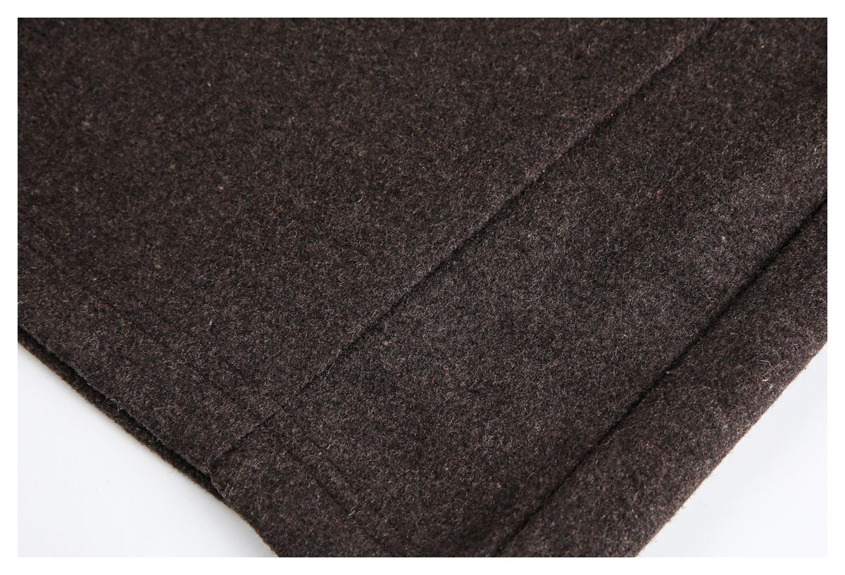 Close-up of dark brown trouser fabric and a stitched seam near the leg edge.