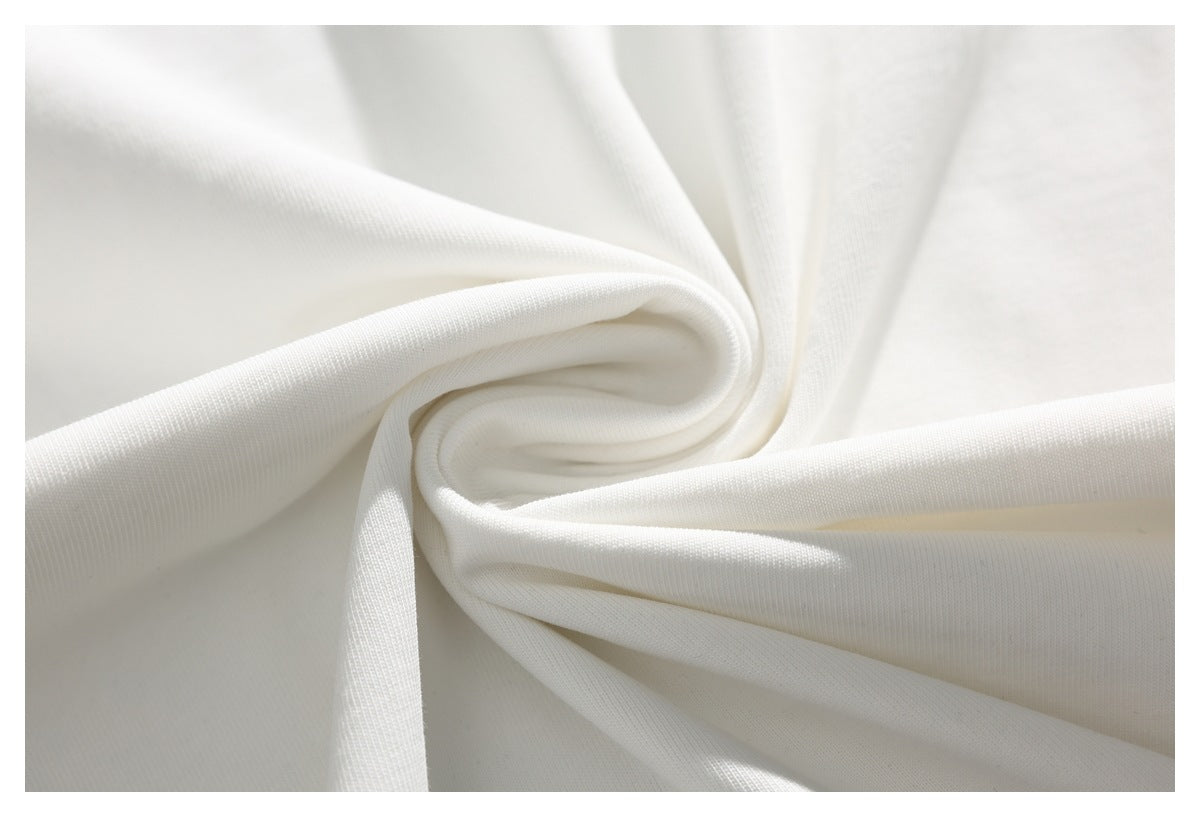 White fabric draped into soft folds, showing its surface and texture.
