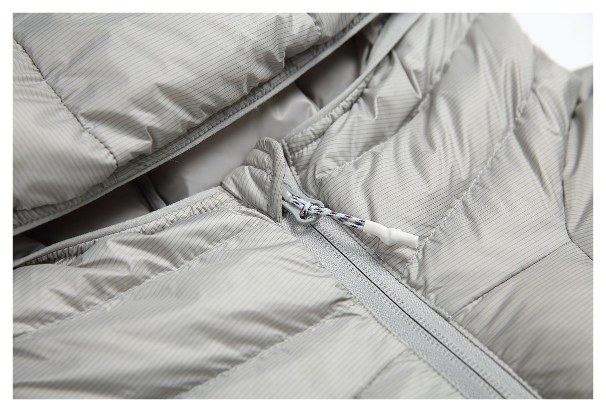 Close-up of a gray pinstriped quilted jacket zipper with a braided pull cord and white tip.