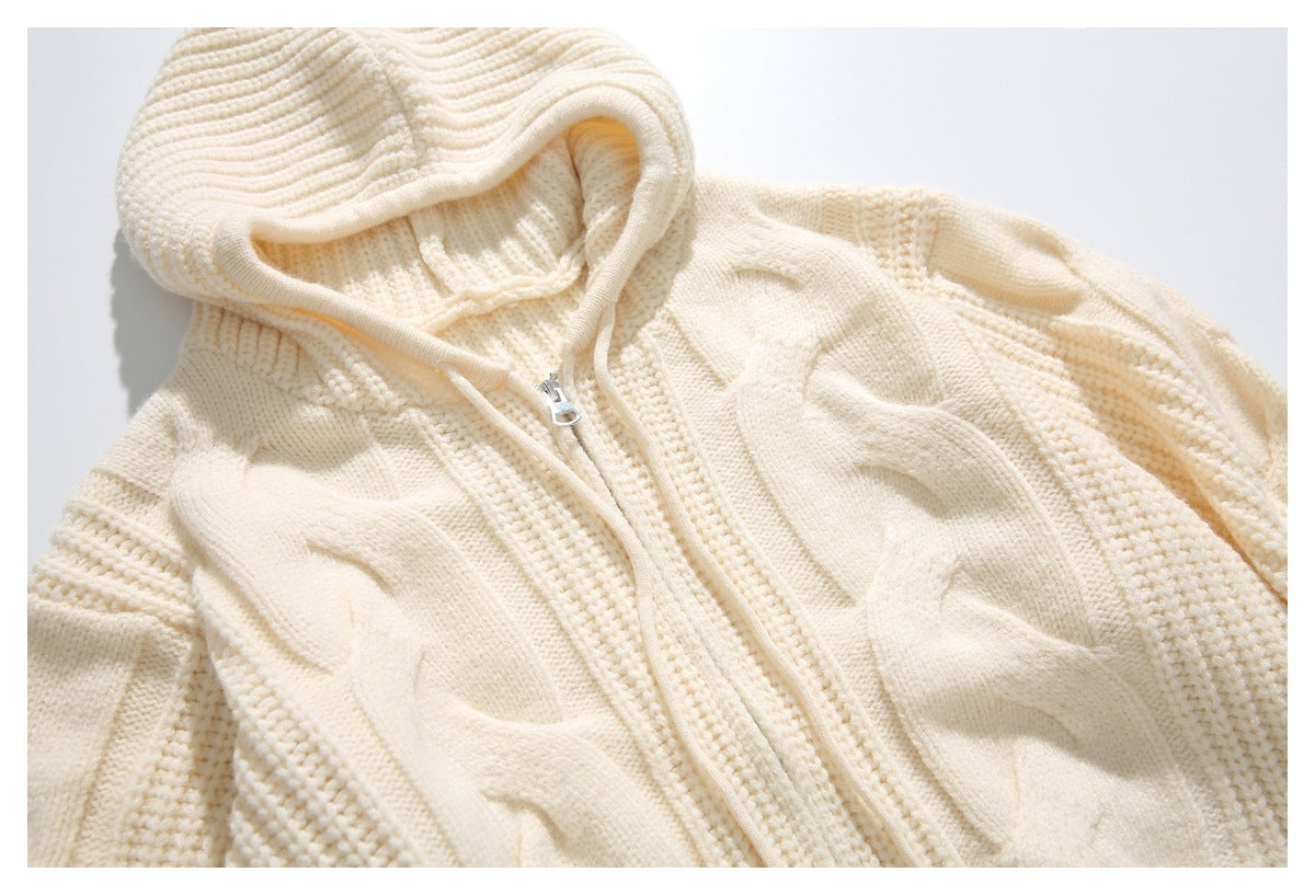 Close-up of the cream hooded sweater's front zipper and raised cable-knit pattern.