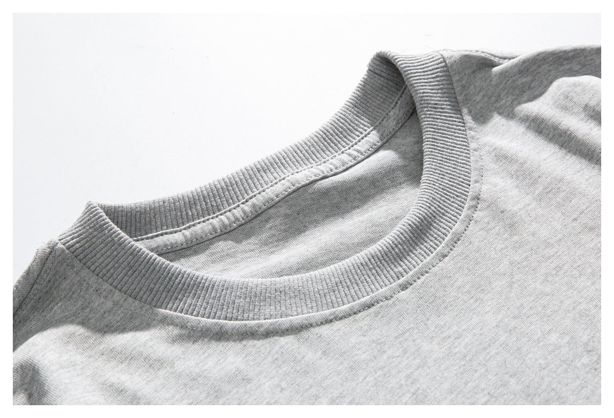 Close-up of a light gray crew-neck shirt showing its ribbed collar and stitching.