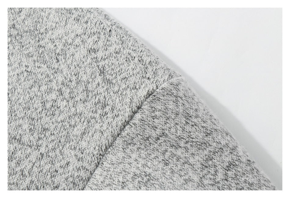 Close-up of a seam joining sections of gray marled knit fabric.