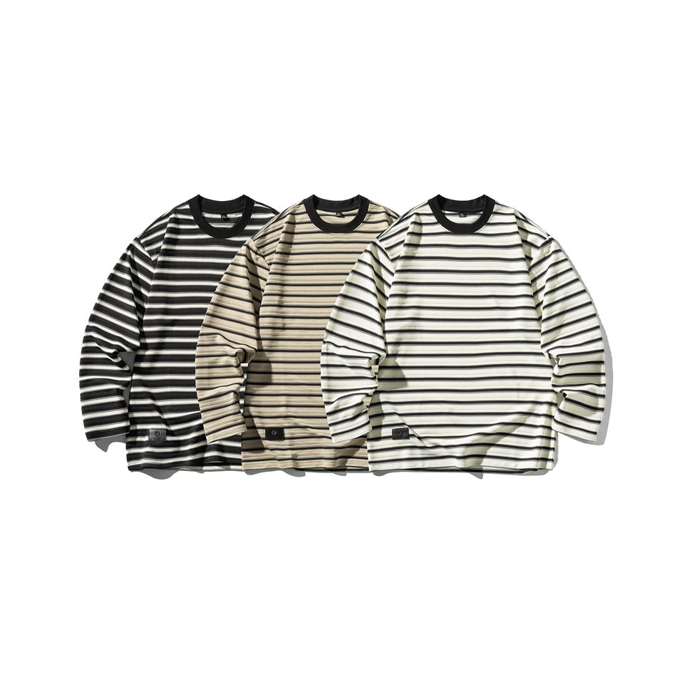 Three long-sleeve striped crew-neck shirts shown in black, beige, and white colorways.
