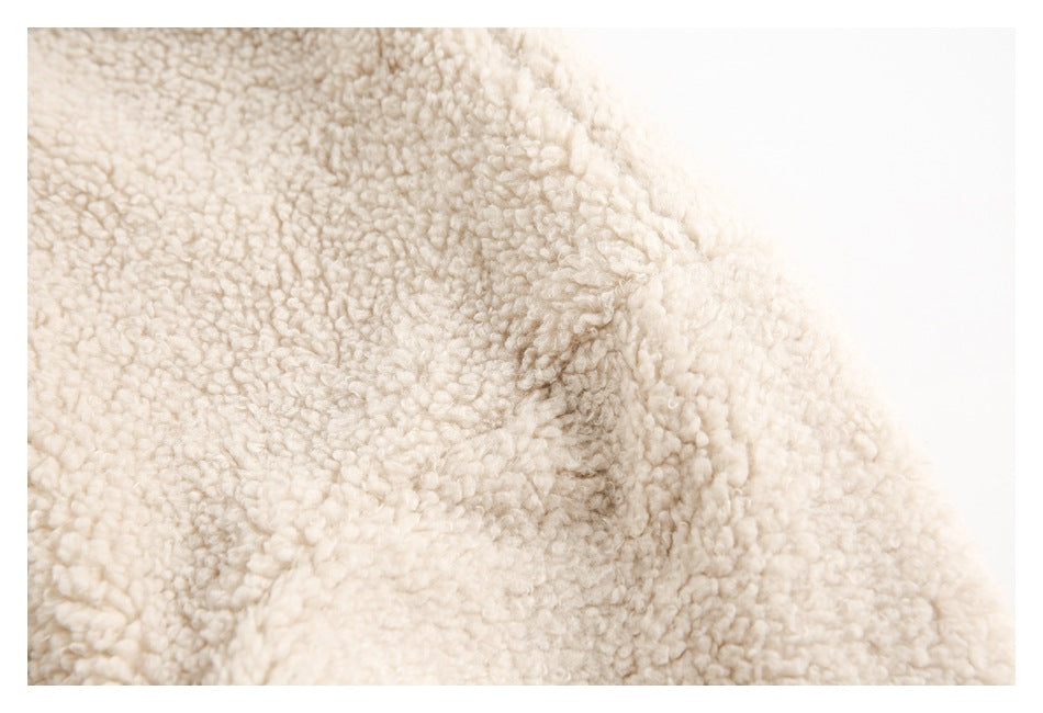 Close-up showing the looped, plush texture and seam of cream jacket fabric.
