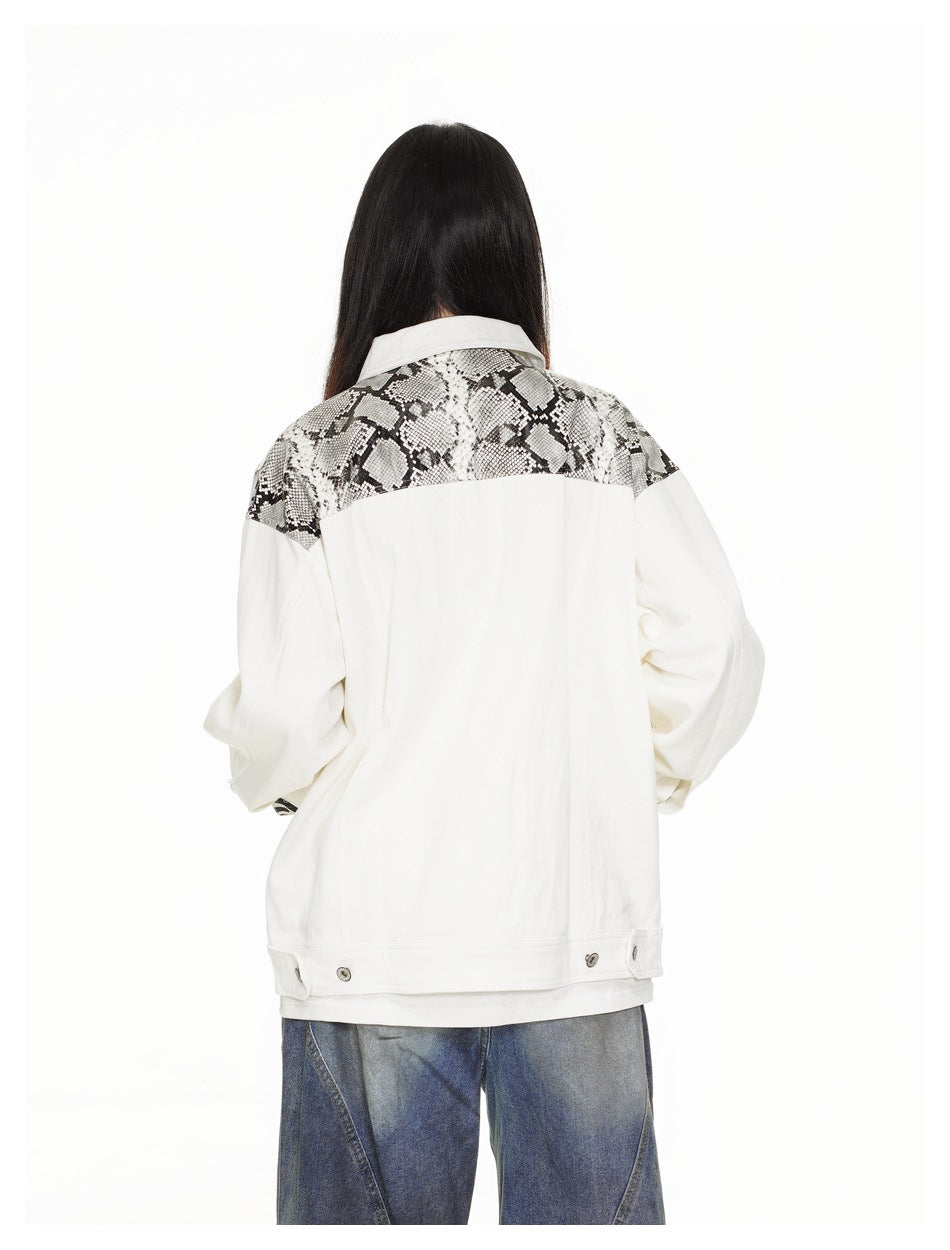 Rear view of a model wearing an oversized white jacket with a black-and-gray snakeskin-patterned shoulder yoke.