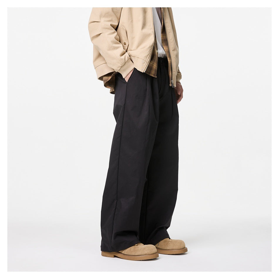 Angled side view of a model wearing loose black wide-leg trousers with a gathered waist.
