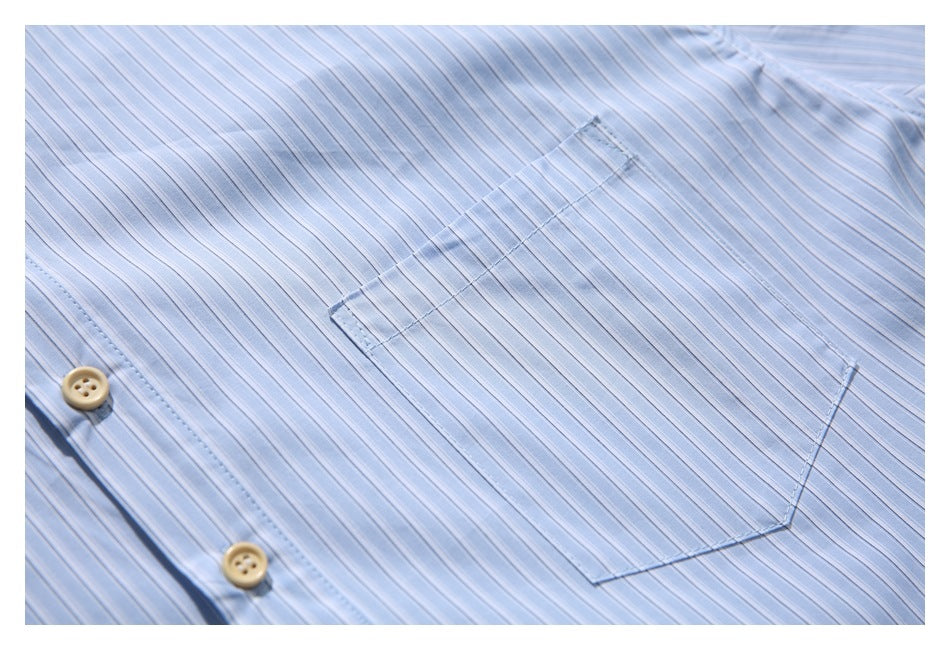 Close-up of a light blue striped shirt showing its chest pocket and button placket.