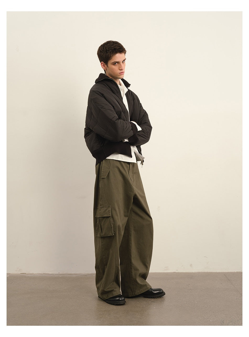 Model wearing olive green wide-leg cargo pants with a black quilted jacket and white shirt, side view