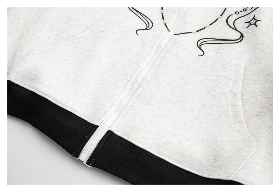 Close-up of a light gray zip-up garment showing its white zipper, front pockets, and black ribbed hem.