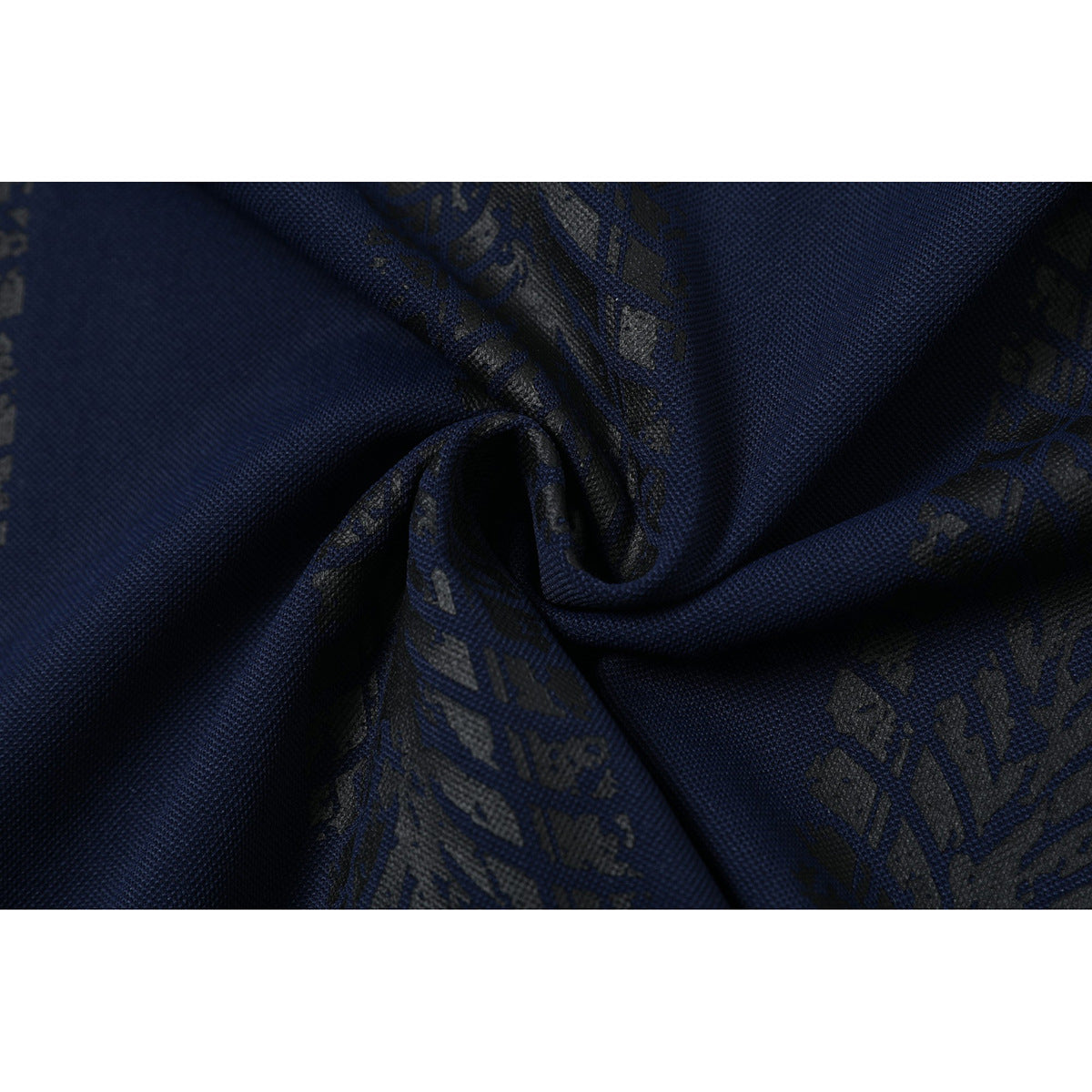 Close-up of navy textured fabric gathered into folds, with a subtle dark repeating pattern.