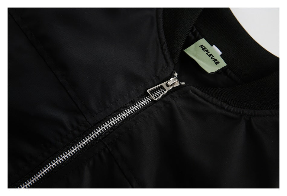 Angled close-up of the jacket's silver zipper, black ribbed collar, and NEPLEURE neck label.