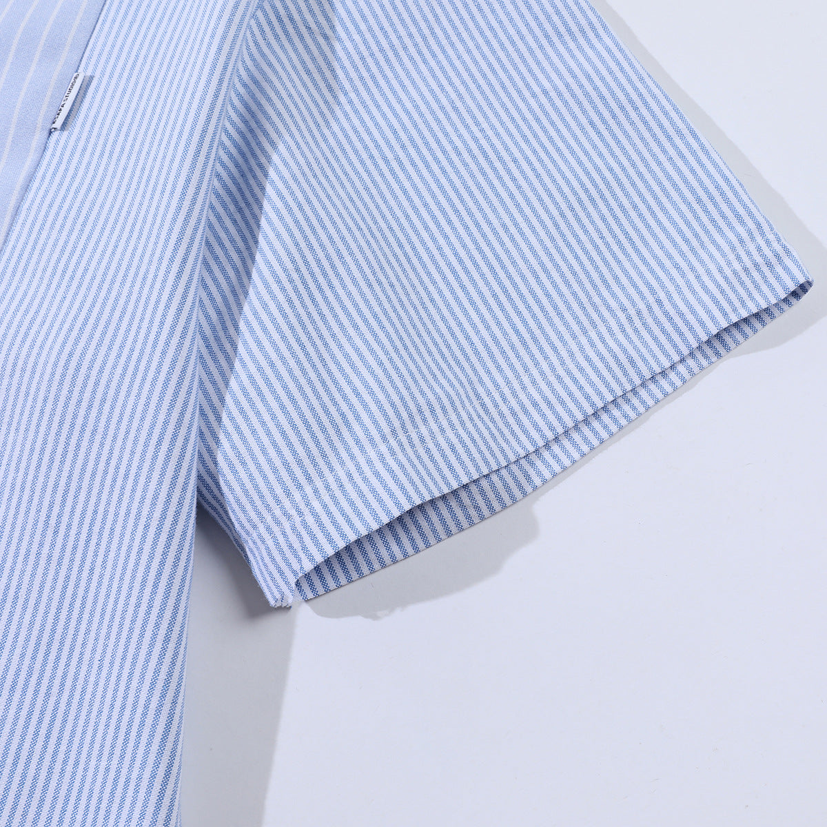 Close-up of a light blue and white striped shirt sleeve and cuff.