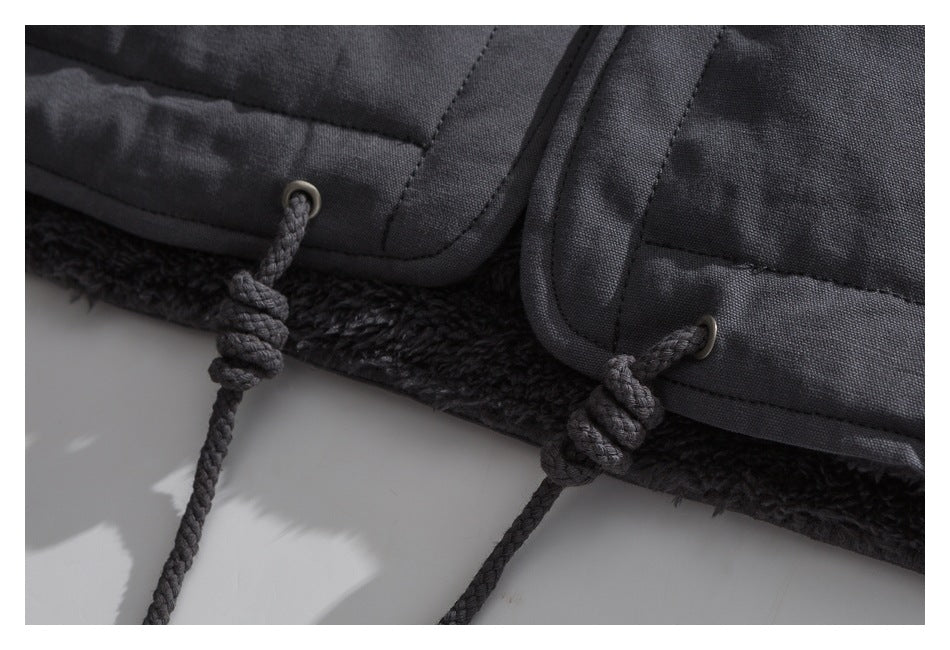 Close-up of the charcoal jacket hem showing plush lining and braided toggle cords through metal eyelets.