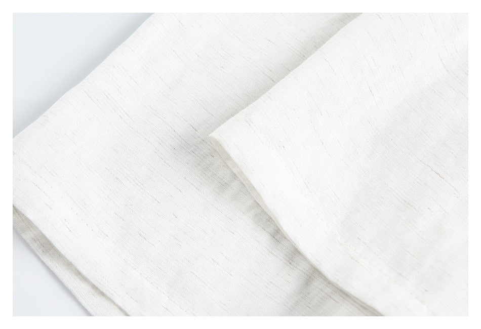 Close-up of overlapping folds of off-white fabric with a fine, subtly slubbed texture.