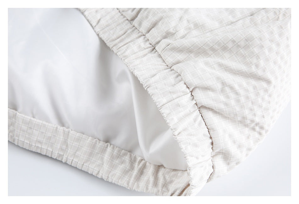 Close-up of the garment's gathered elastic edge and smooth white inner lining.