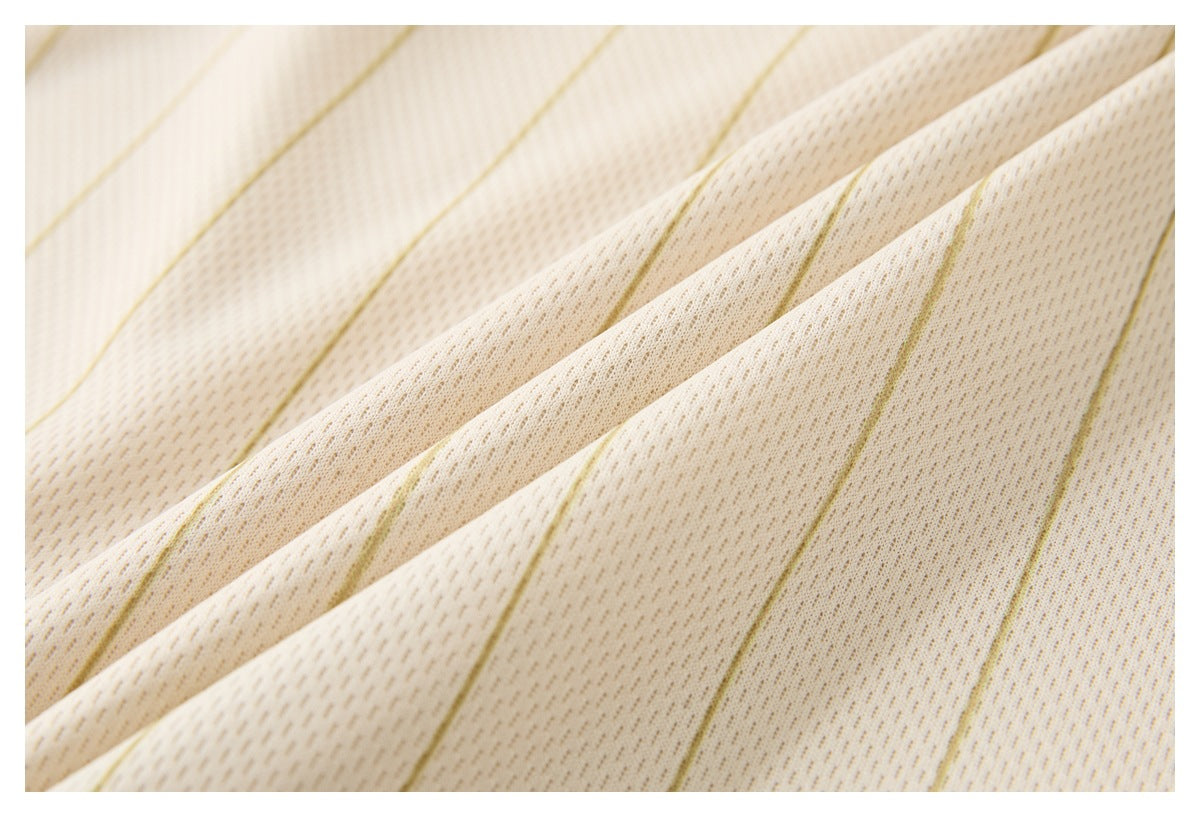 Close-up of cream fabric showing fine gold pinstripes and its textured knit surface.