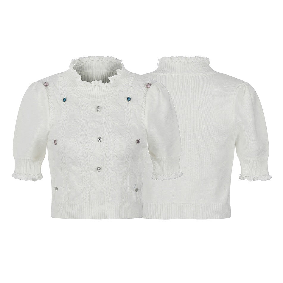 White sweater shown from front and back, with puff sleeves, a ruffled high neck and cuffs, cable-knit front, and jewel