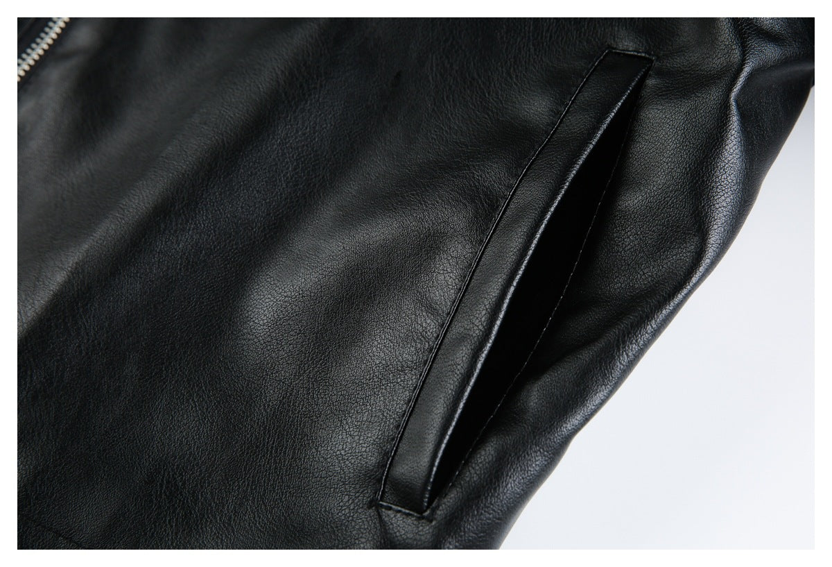 Close-up of a slanted welt pocket on a black jacket, with part of a silver zipper visible.