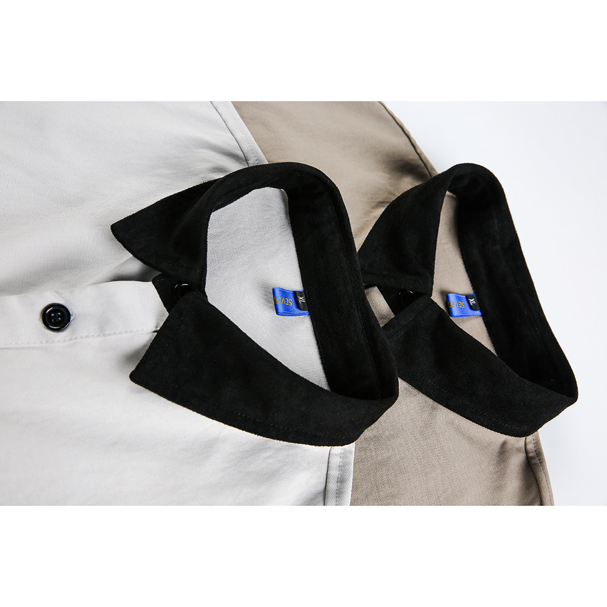 Close-up of the black collars and neck labels on the light gray and taupe shirts.