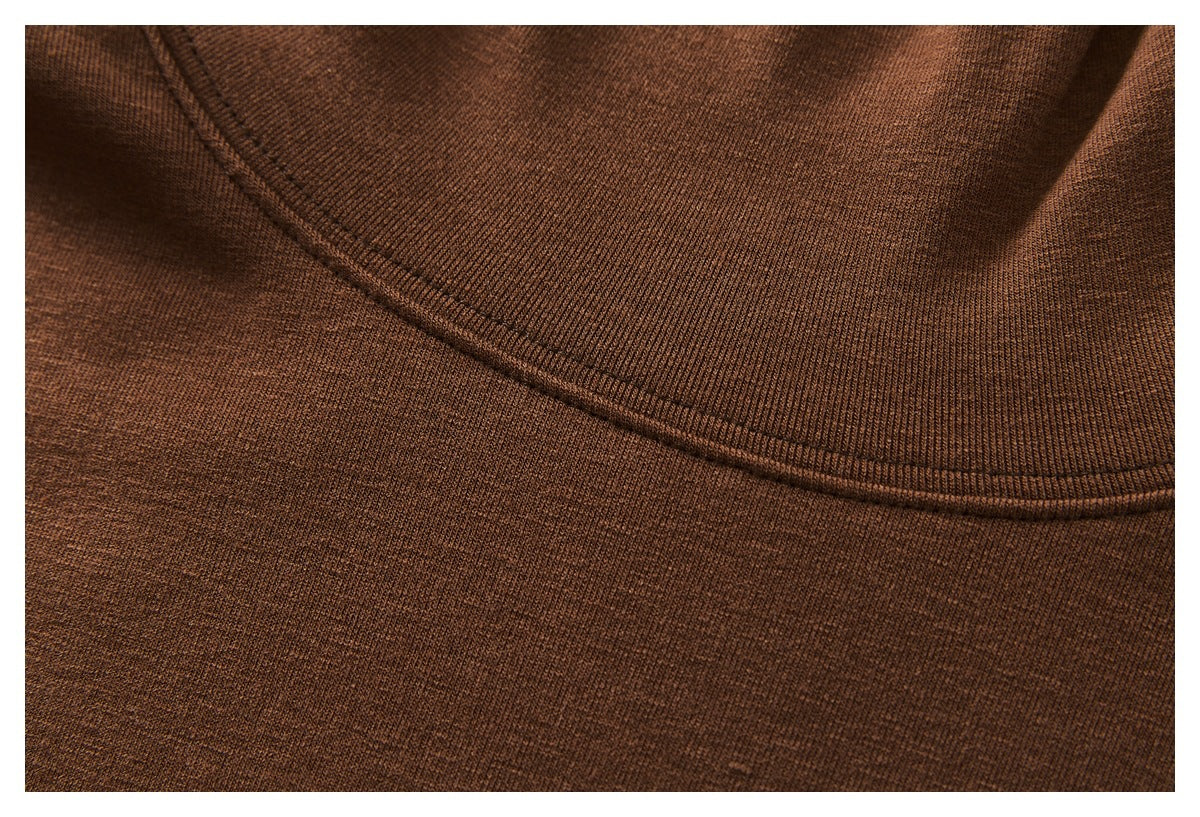 Close-up of brown knit garment fabric showing a curved neckline seam and stitching.