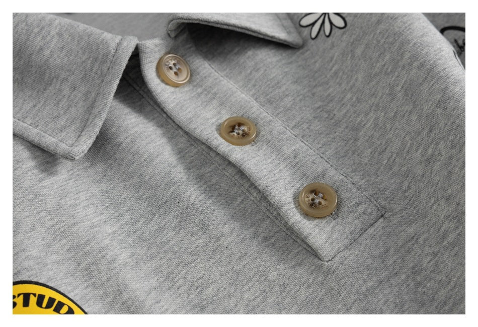 Close-up of a gray shirt's pointed collar and tan three-button placket.