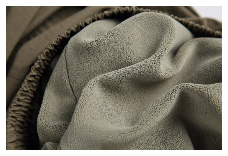 Close-up of the light gray textured lining inside olive-brown pants.