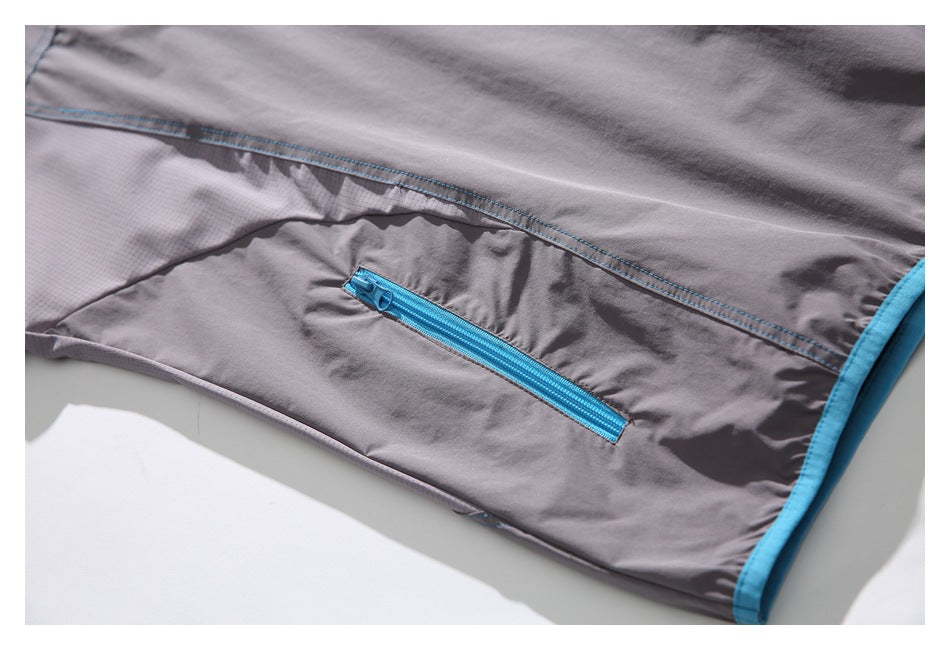 Close-up of the gray shirt's side seam and bright blue zippered pocket.