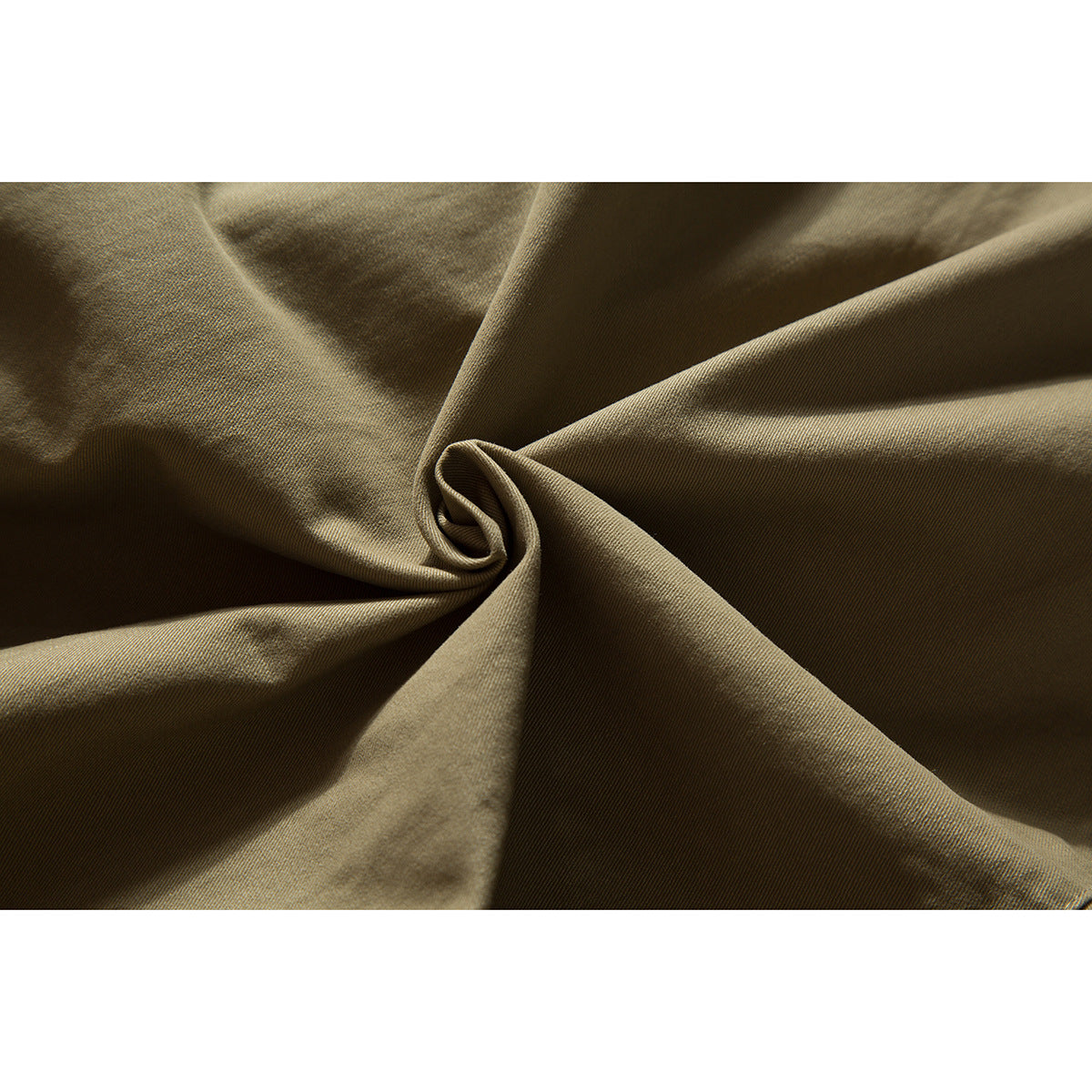 Close-up of olive-khaki fabric gathered into folds, showing its surface texture.