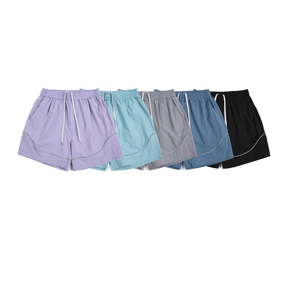 Five pairs of drawstring athletic shorts shown together in lavender, aqua, gray, blue and black.