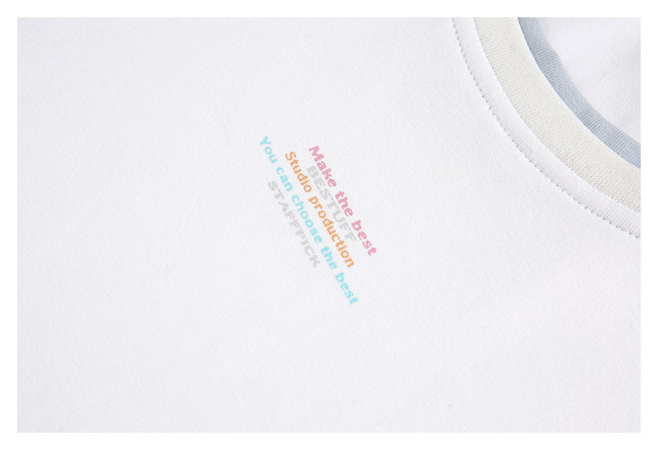 Close-up of multicolor English text printed on the chest of a white shirt.