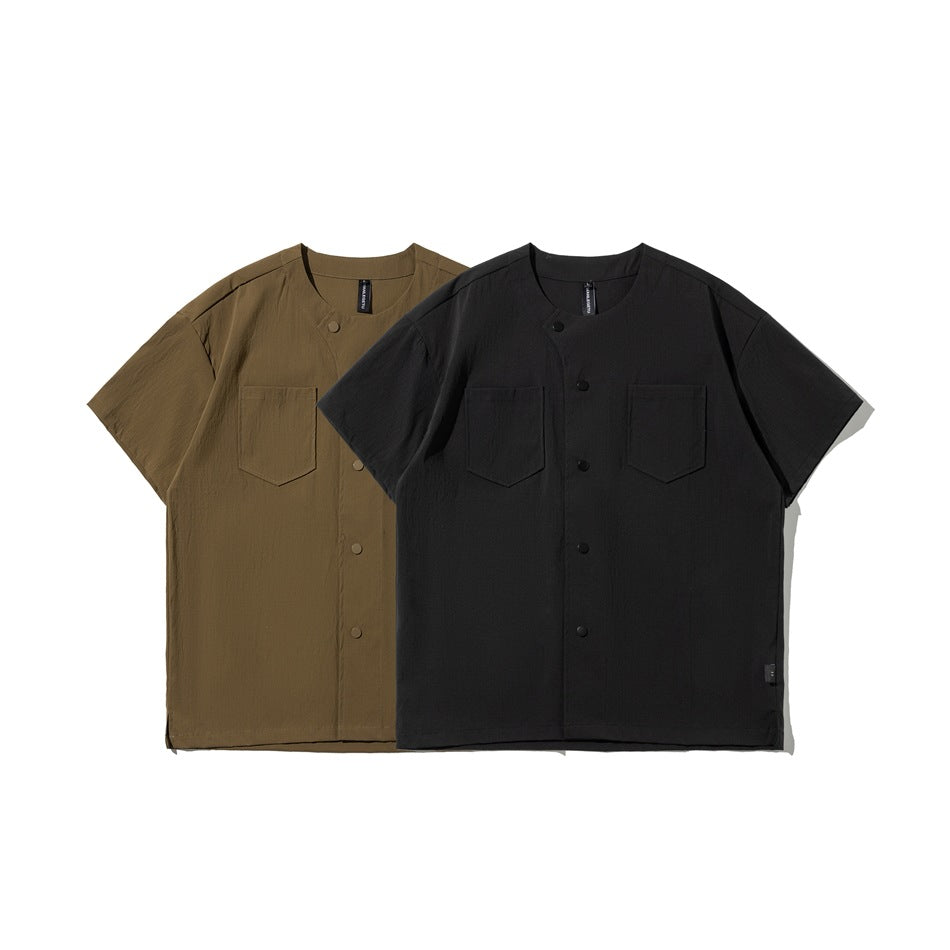 Front view of short-sleeve, button-front shirts in olive-brown and black, each with two chest pockets.