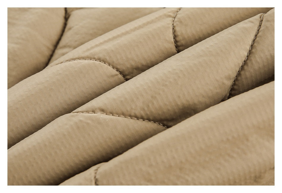 Close-up of beige quilted fabric showing raised padded channels and stitching.