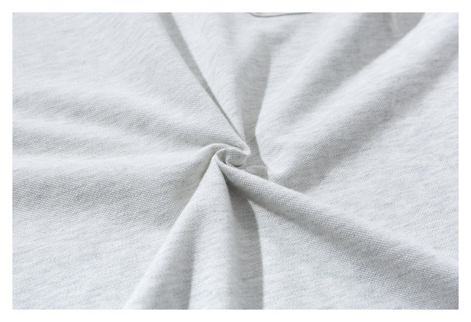 Close-up of light gray shirt fabric gathered into a twist.