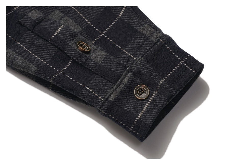 Close-up of the charcoal plaid shirt's sleeve cuff with two buttons.