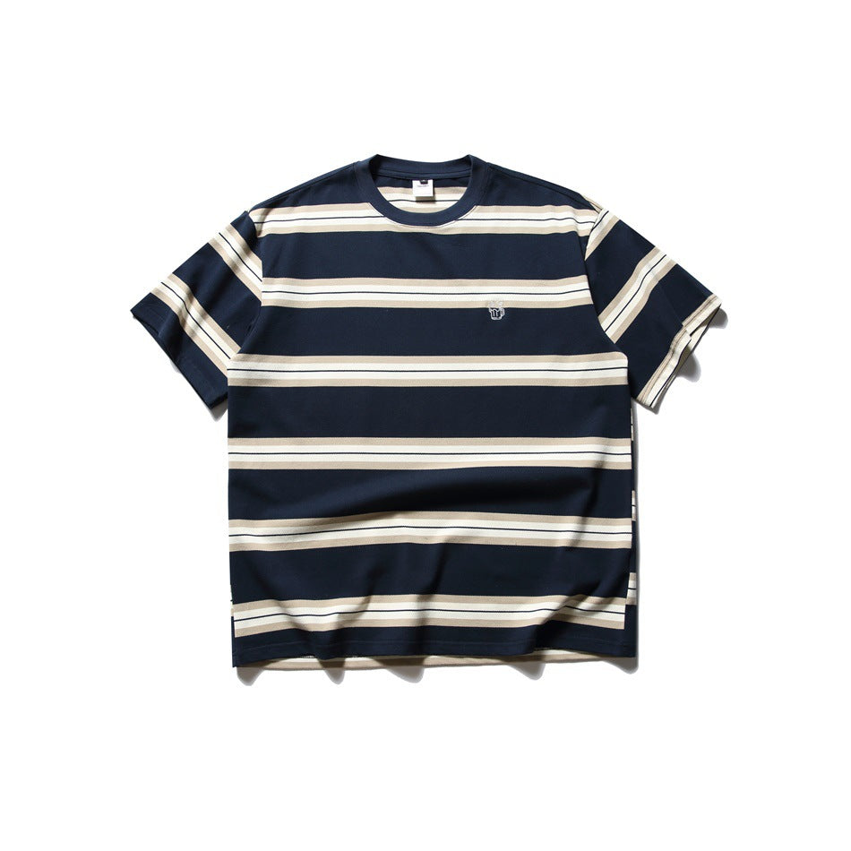Navy short-sleeve crew neck T-shirt with cream and tan horizontal stripes and a small embroidered chest mark, flat lay
