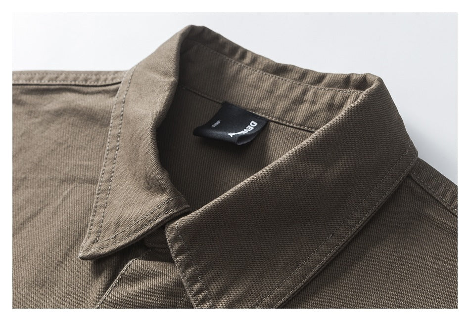 Close-up of the olive-brown shirt collar, stitching, and sewn-in neck label.