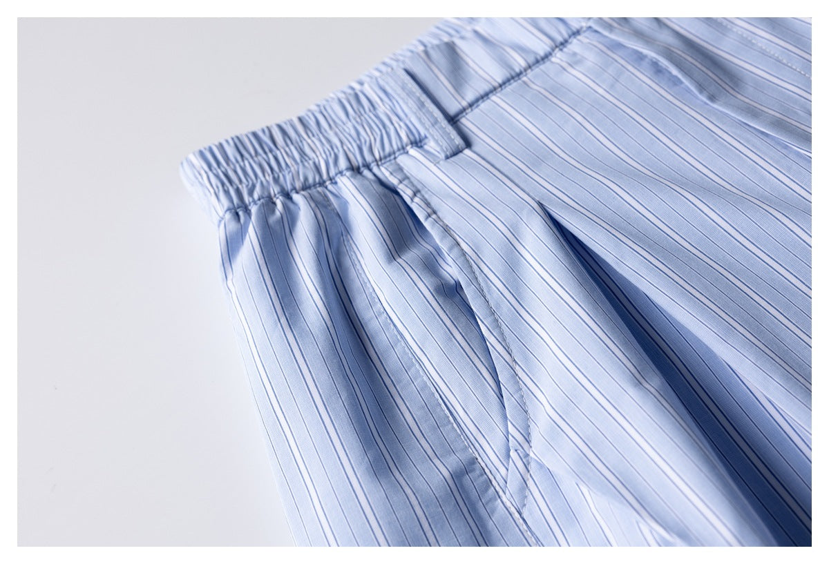 Close-up of light blue striped shorts showing the gathered elastic waistband and pleated fabric.