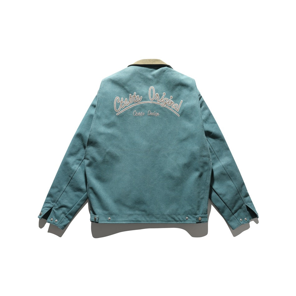Back view of teal jacket with large embroidered script lettering, olive collar and snap tabs at hem and cuffs